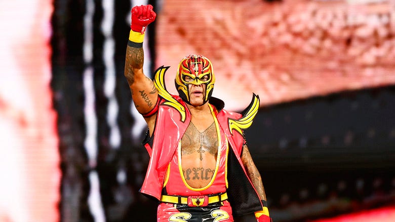 Rey Mysterio makes an entrance with a raised fist
