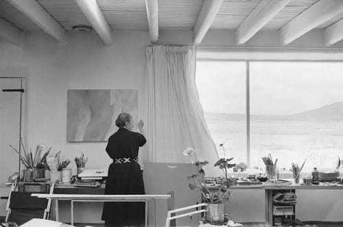 A photo of Georgia O'Keeffe working in her studio