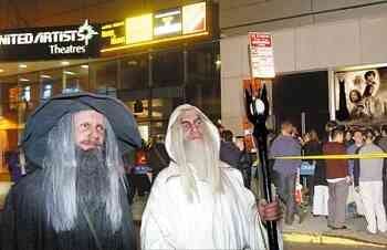 Two men dressed as Lord of the Rings characters entering a movie theater in New York City.
