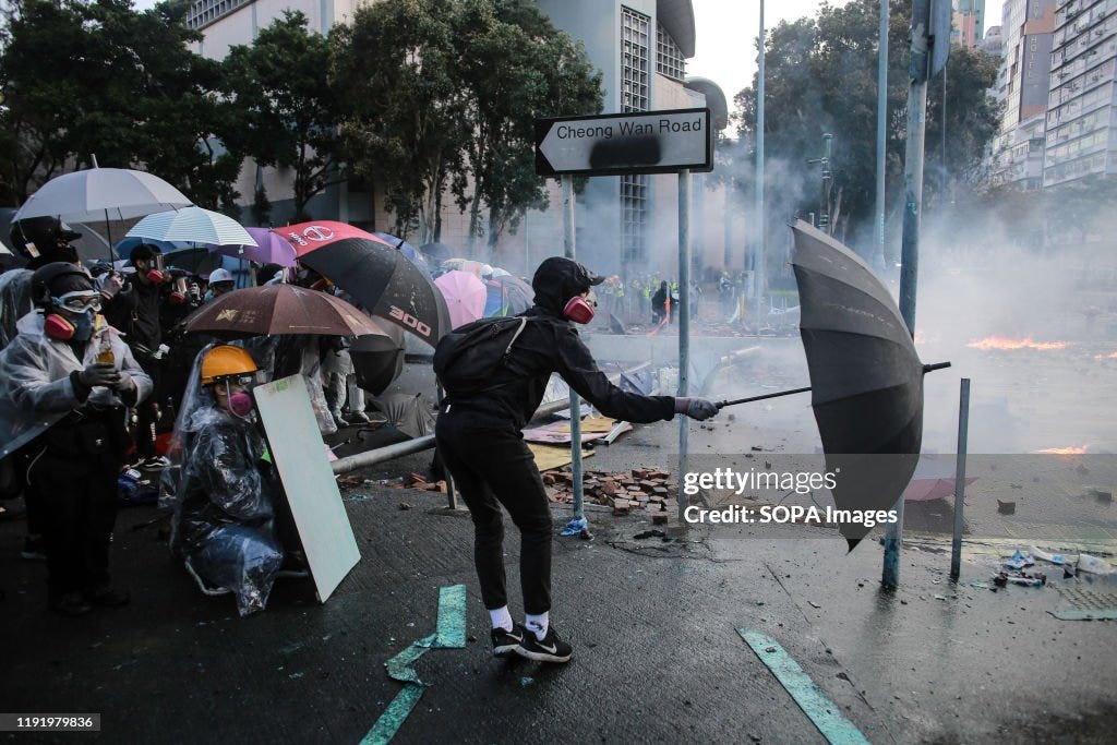 Protesters use umbrellas as shields during the demonstration...