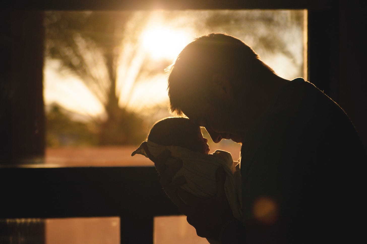 picture of caregiver taking baby outside to see the sunrise