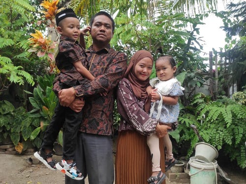 Woman and man posing for a photo with 2 children.