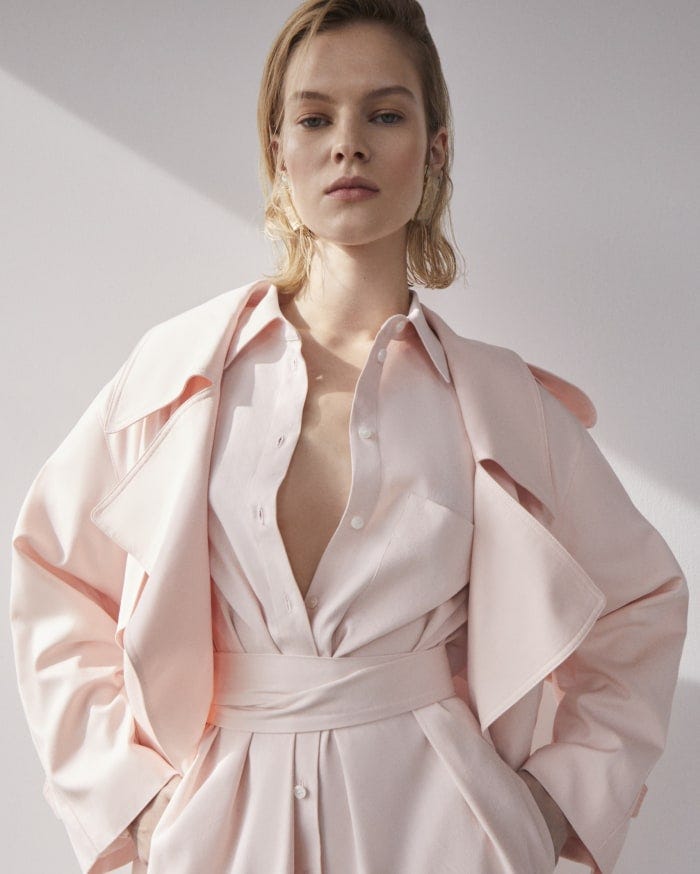 Model wearing a belted pale pink shirt dress and jacket.