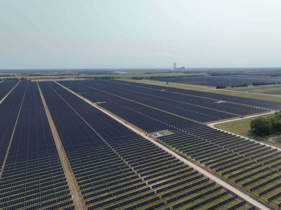 Outside the plant, solar panels span acres of farmland. Sherco — a fossil fuel behemoth — looks small in comparison.