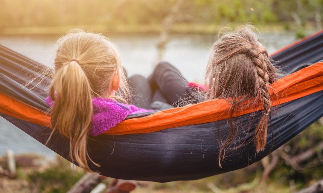 two women lying on hammock two women lying on hammock