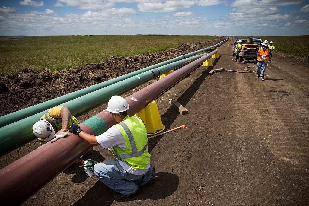 Construction workers specializing in pipe-laying work on a section of pipeline