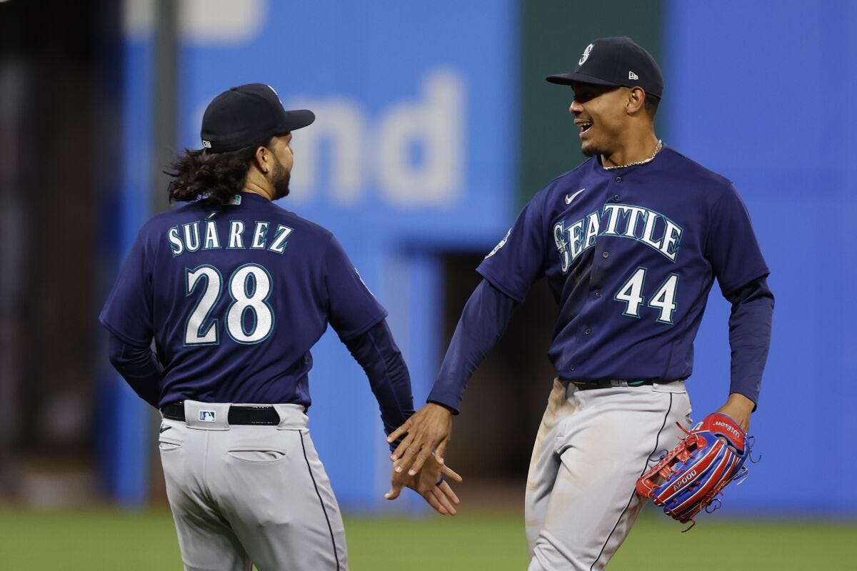 Seattle Mariners third baseman Eugenio Suarez (28) and center fielder Julio Rodriguez (44) celebrate the team's 3-2 win against the Cleveland Guardians in a baseball game, Saturday, April 8, 2023, in Cleveland. (AP Photo/Ron Schwane)
