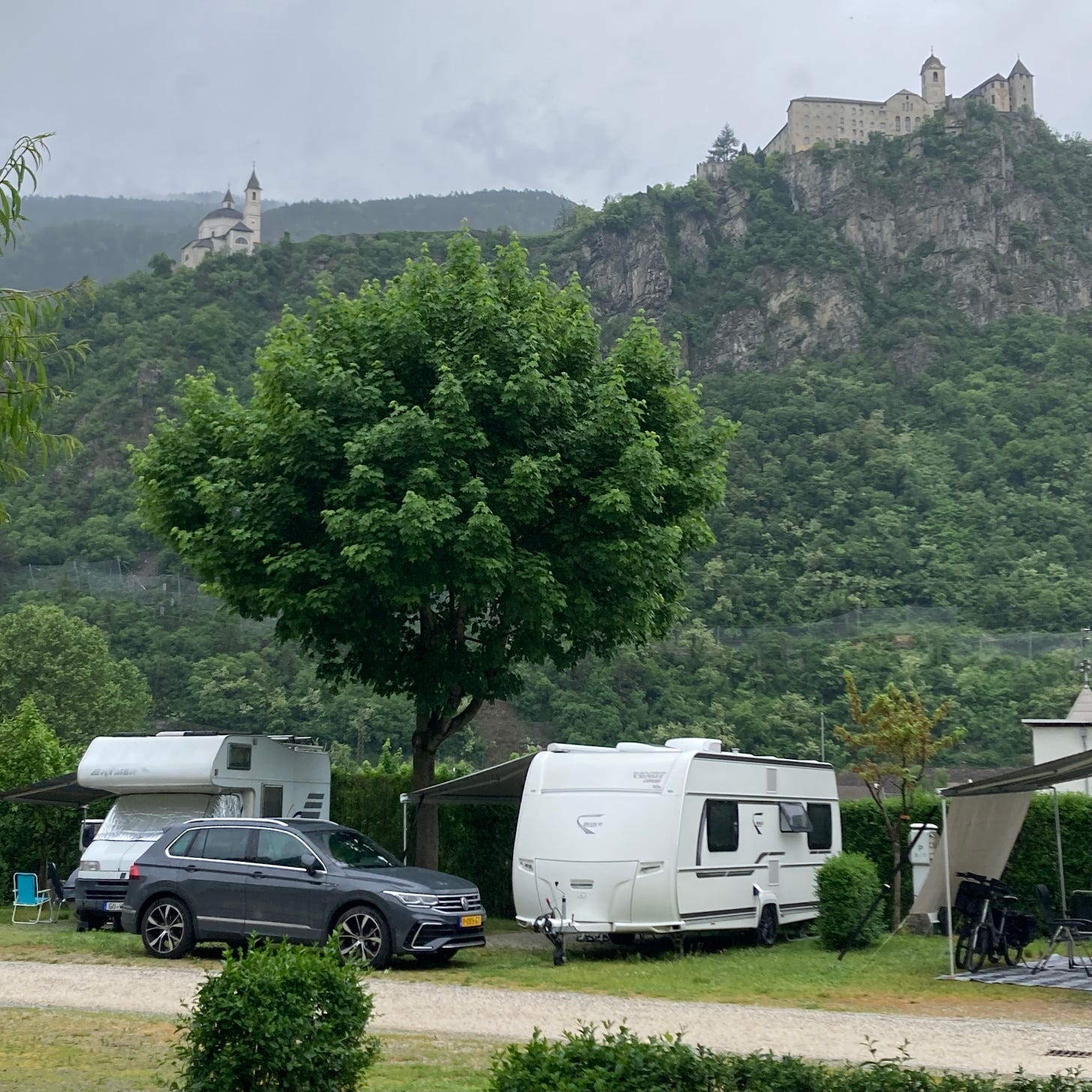 Photo of campground with hills in back holding a medieval castle and monastery