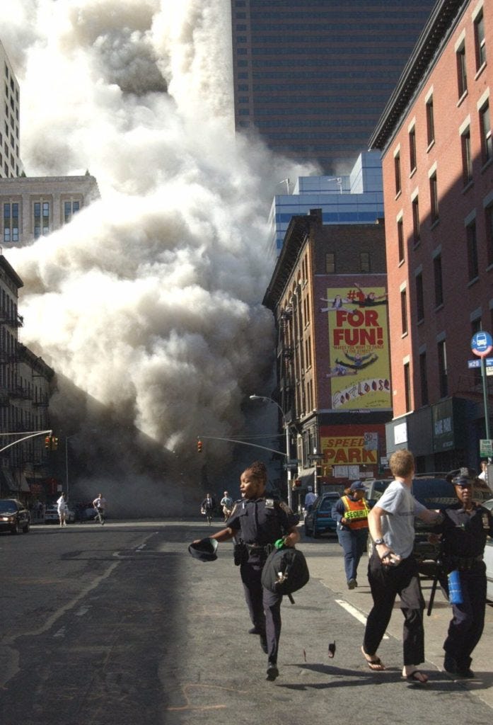 Police officers and civilians run away from New York's World Trade Center after an additional explosion rocked the buildings Tuesday morning, Sept. 11, 2001. In unprecedented show of terrorist horror, the 110-story World Trade Center towers collapsed in a shower of rubble and dust Tuesday morning after two hijacked airliners carrying scores of passengers slammed into the sides of the twin symbols of American capitalism. (AP Photo/Louis Lanzano)