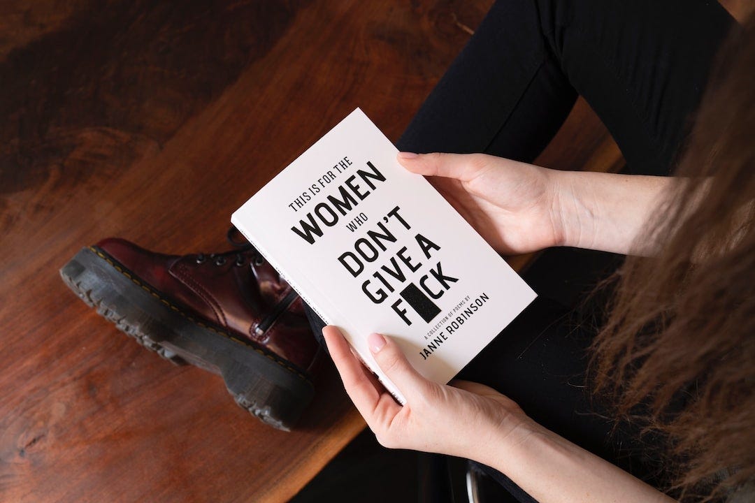 woman holding This is for the women who don't give a fuck book