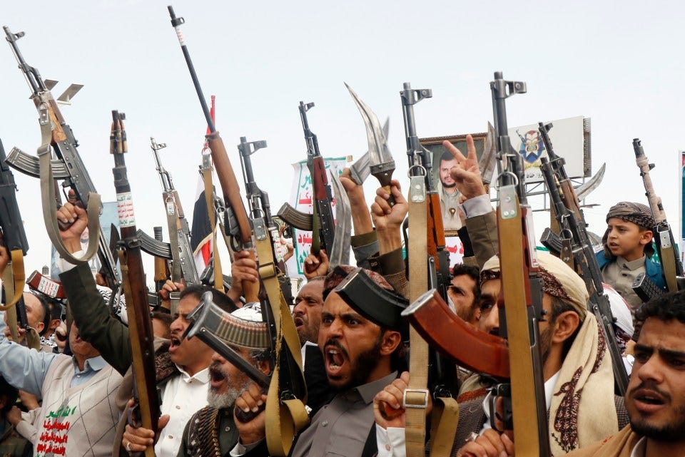 Houthi supporters in Sana'a, Yemen, brandishing weapons at a demonstration.