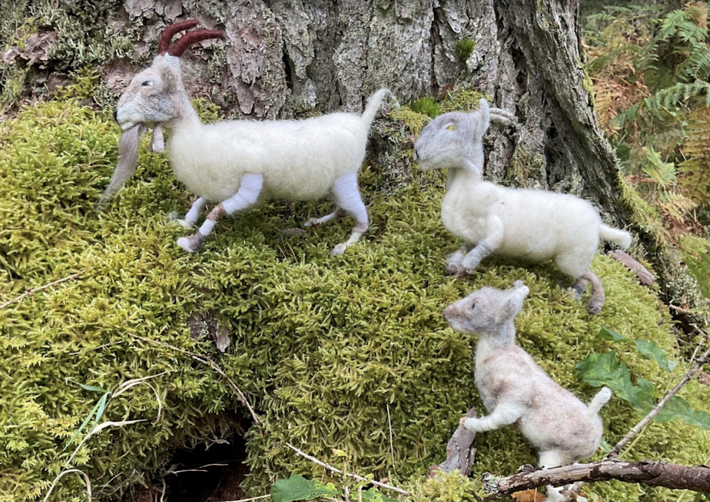 handmade, felted goat puppets on a mossy background