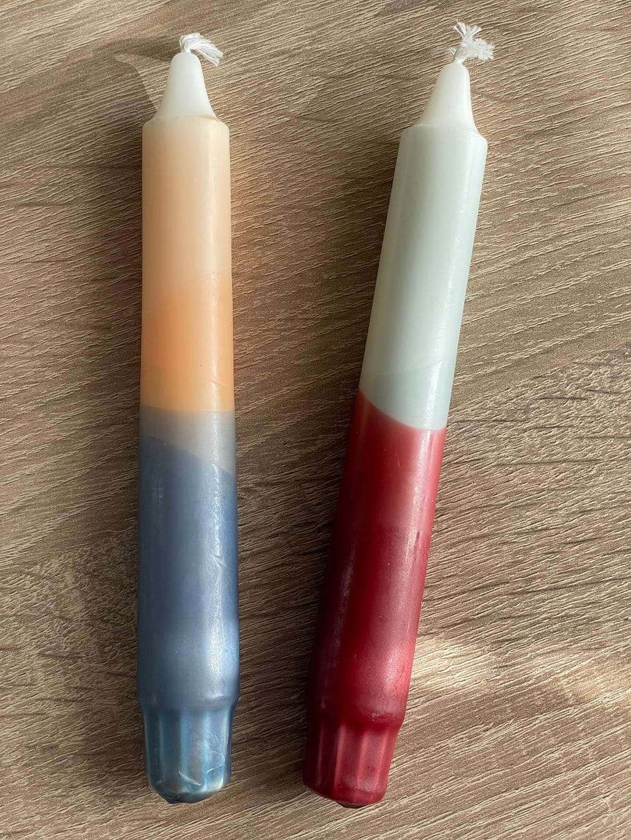Photo of two candles in different colours: peach and blue and mint and burgundy.