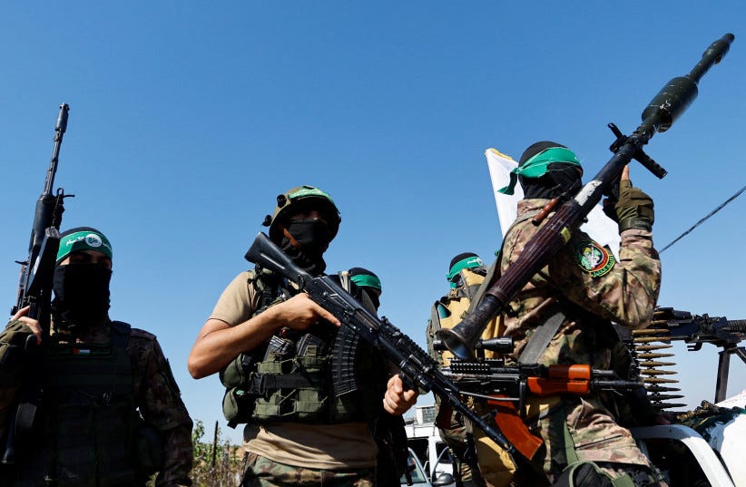  Palestinian fighters from the armed wing of Hamas take part in a military parade to mark the anniversary of the 2014 war with Israel, near the border in the central Gaza Strip, July 19, 2023. (photo credit: REUTERS/IBRAHEEM ABU MUSTAFA)