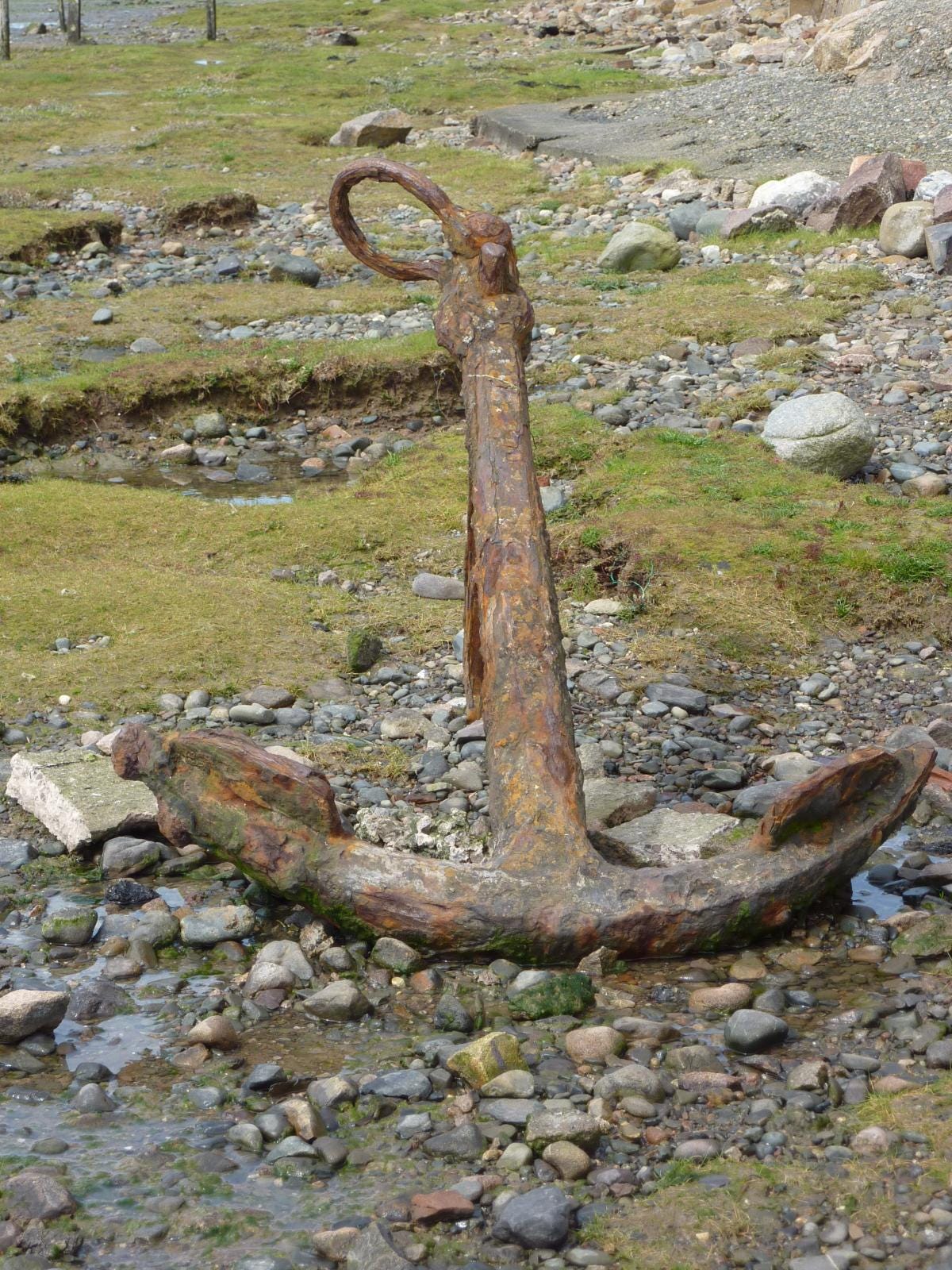 Rusting anchor on stony beach Rusting anchor on stony beach
