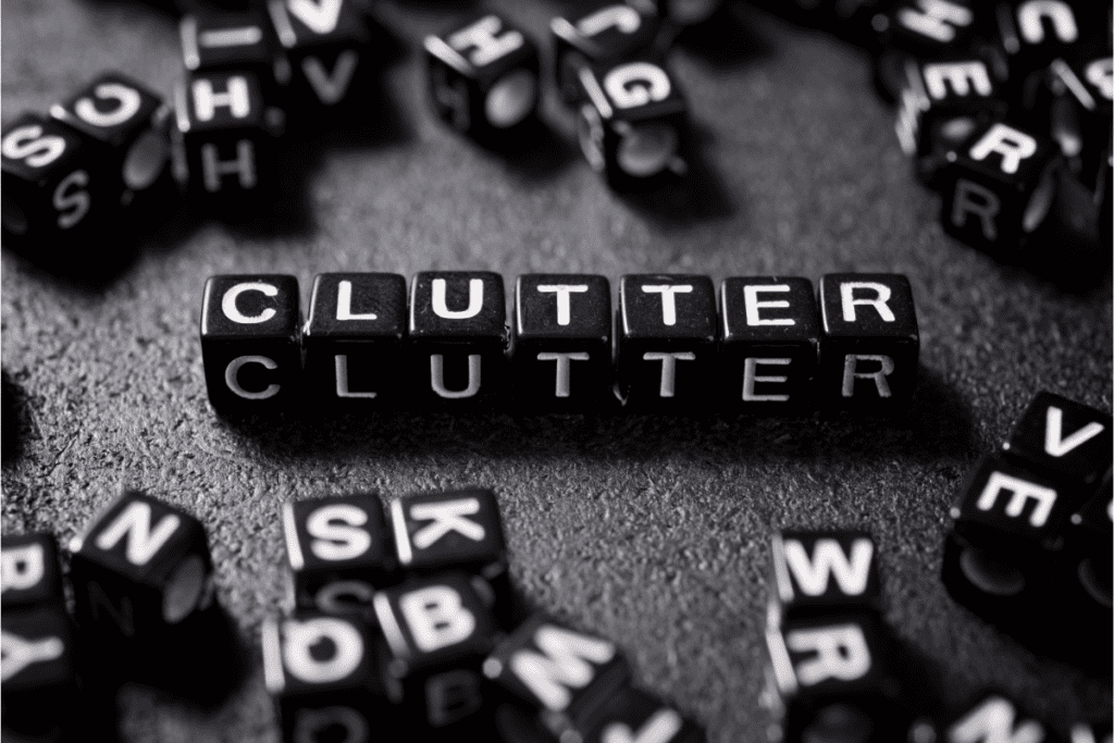 The word clutter spelled out with white letters on small black cubes surrounded by other cubes scattered