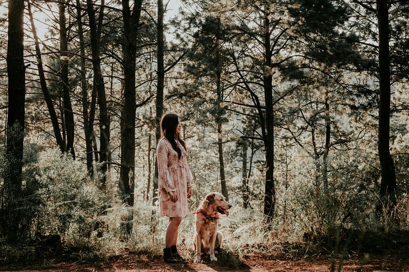 Woman with dog, in woods