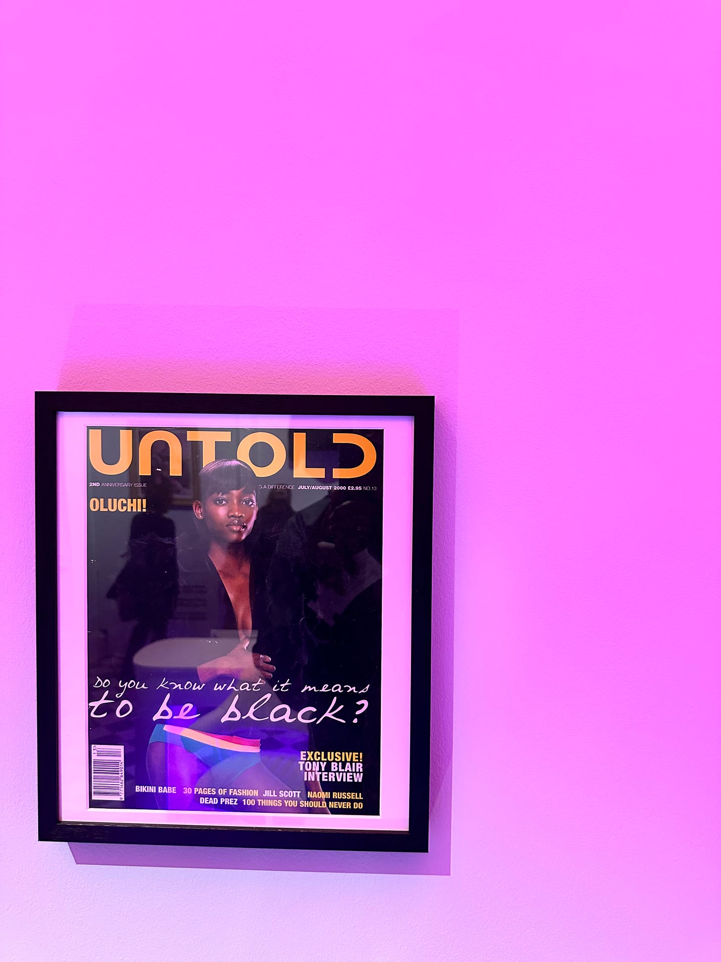 Framed cover of UNTOLD magazine, a late 1990s magazine for British Black men showing a young black woman on the cover with the headline "Do you know what it means to be Black?".