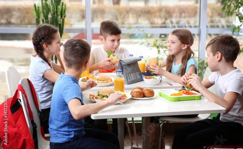 "Children sitting at cafeteria table while eating lunch" Stockfotos und lizenzfreie Bilder auf ...