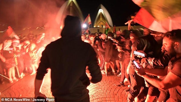 There were scenes of chaos as the demonstration was hijacked by radical Muslims - some wearing black masks - who hurled lit flares at police and chanted 'f*** Israel' and 'f*** the Jews' beneath the steps of the Opera House (pictured)