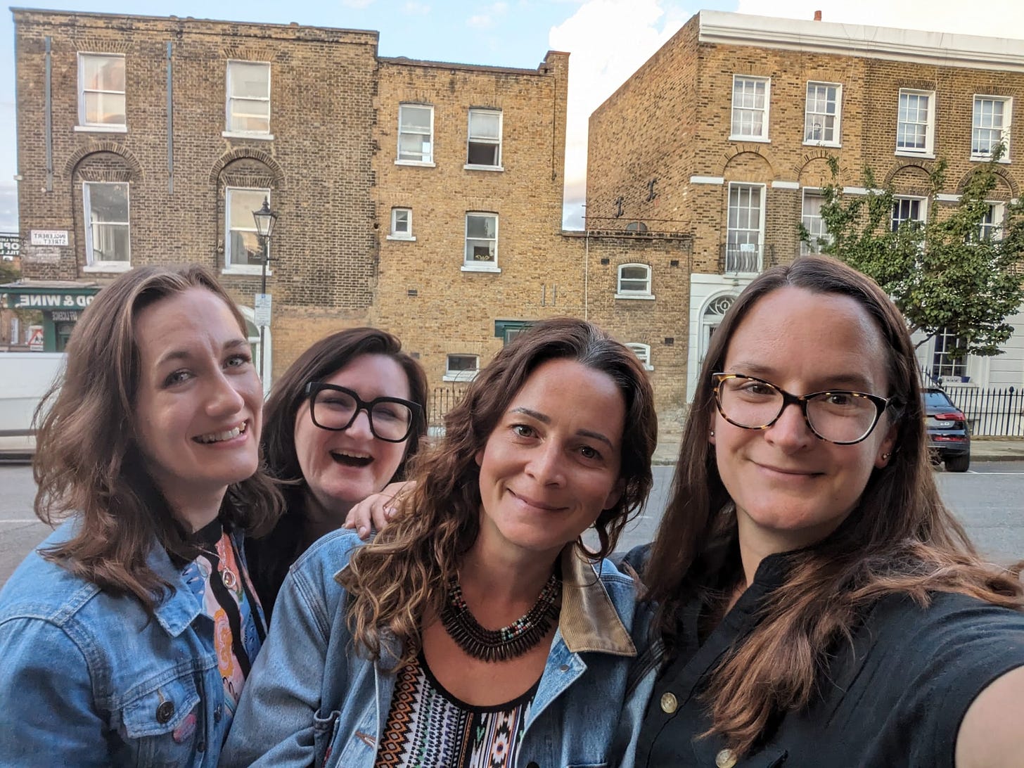 Four white women with brown hair stand in front of some lovely very expensive Londony buiildings. Francesca Lawson, Bonnie Harrington, Sophie Cross and Mel Barfield