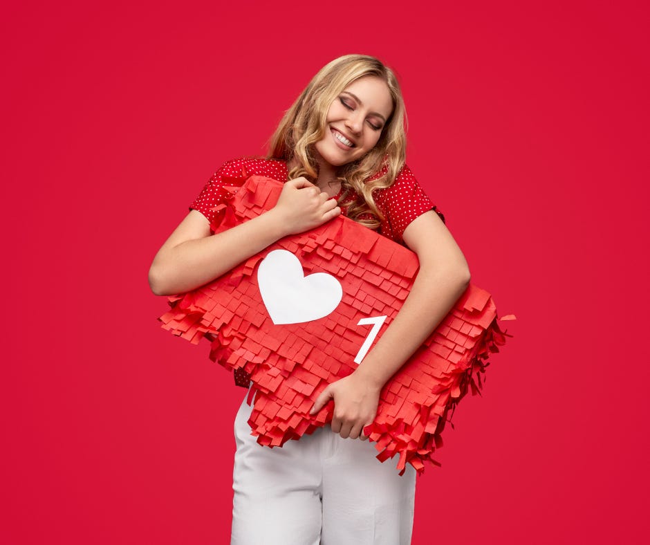 Blonde woman hugs red paper mache version of an Instagram LIKE button