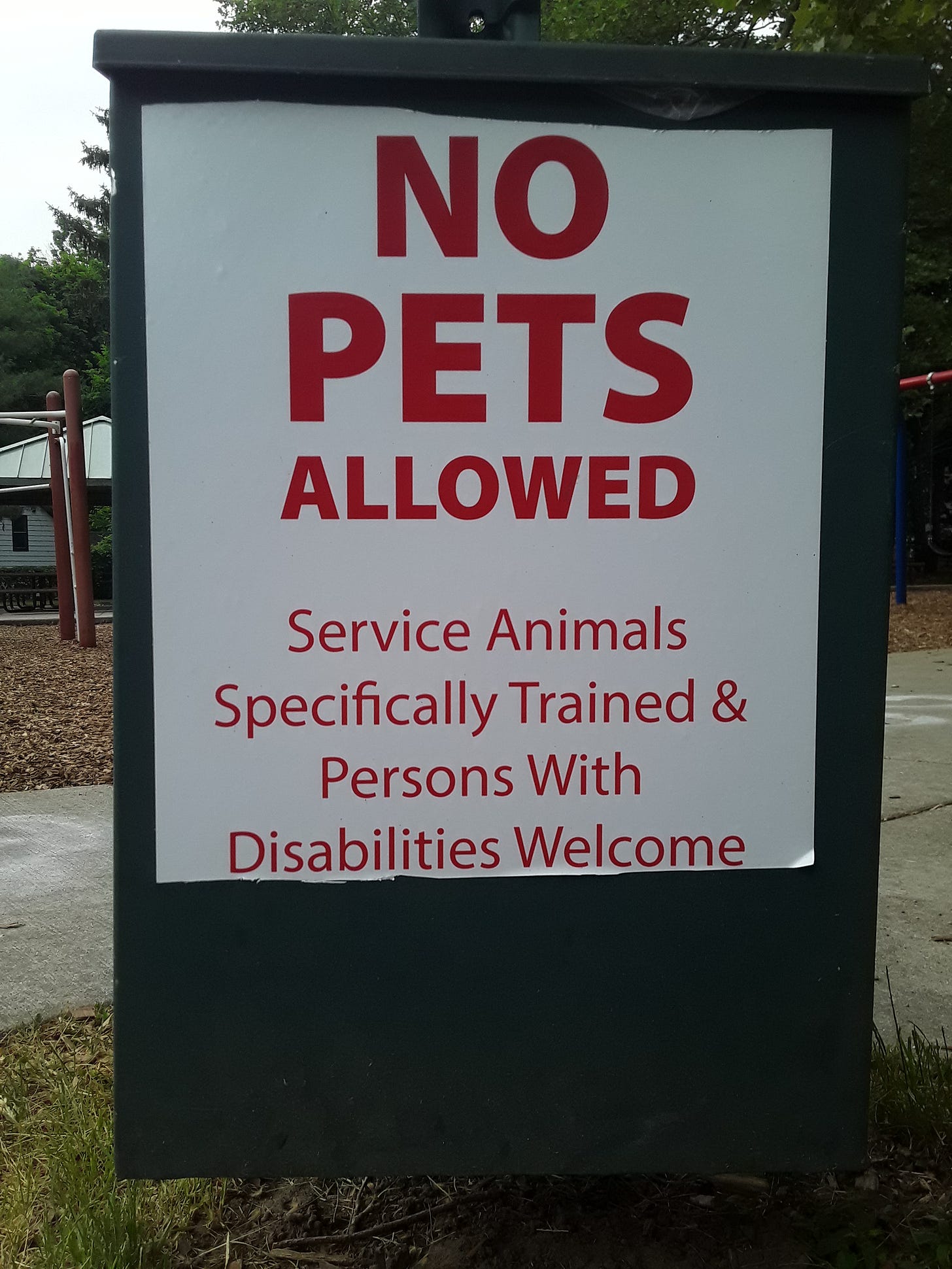 Photograph of the dog waste bin in Davis Street Park, showing a sign that reads "NO PETS ALLOWED.  Service Animals Specifically Trained & Persons With Disabilities Welcome".