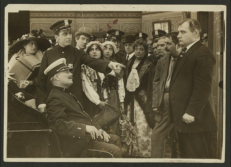 Still from 1913 film Traffic in Souls, showing criminals and victims gathered at the police station after the raid