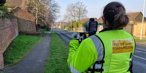 Roads Policing staff using a speed detection device at the side of the road