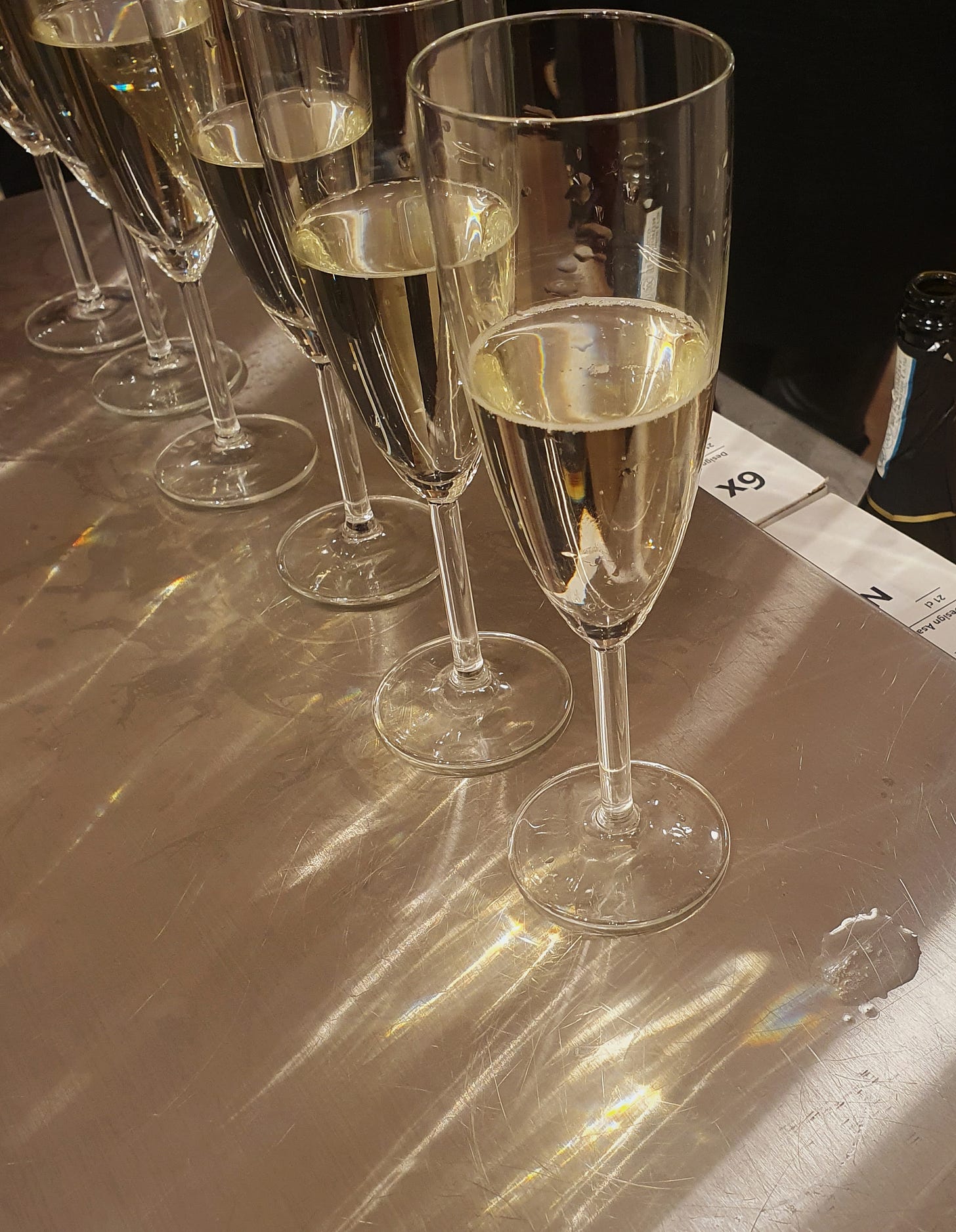 A row of glasses of champagne with the light refracting through them