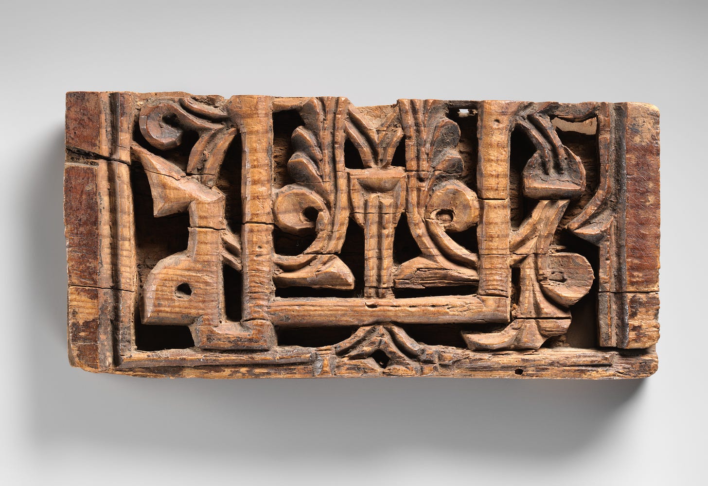 The program of interior decoration for Andalusian palatial residences included a tile dado surmounted by carved stucco or stone, crowned by wooden friezes and cornice elements. This panel is probably a fragment of such a frieze. Carved in deep relief, it bears part of an inscription in kufic script against a vegetal background.