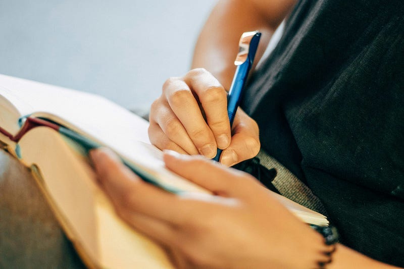 Person writing in notebook Person writing in notebook