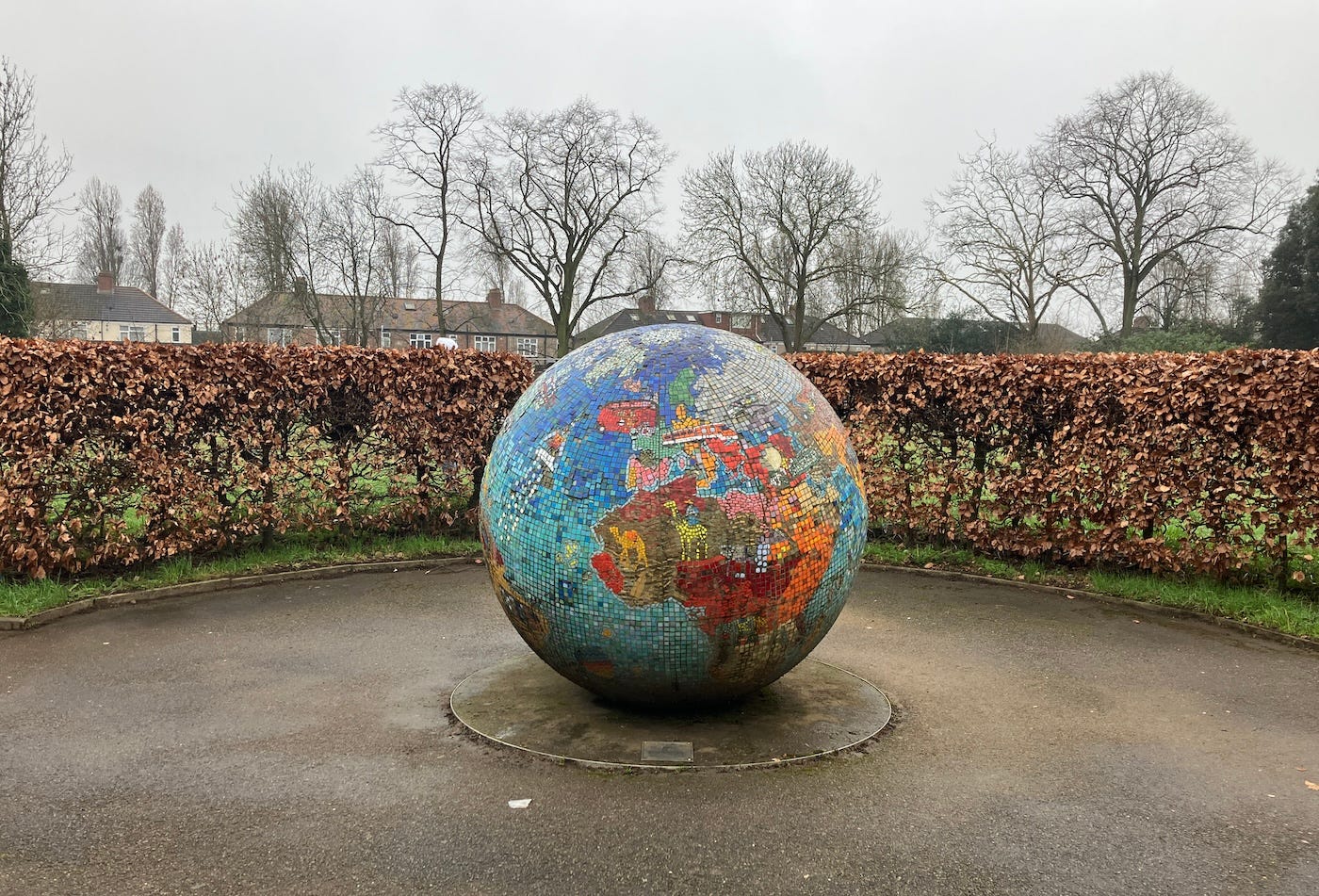 A large concrete ball with a colourful mosaic of the world map