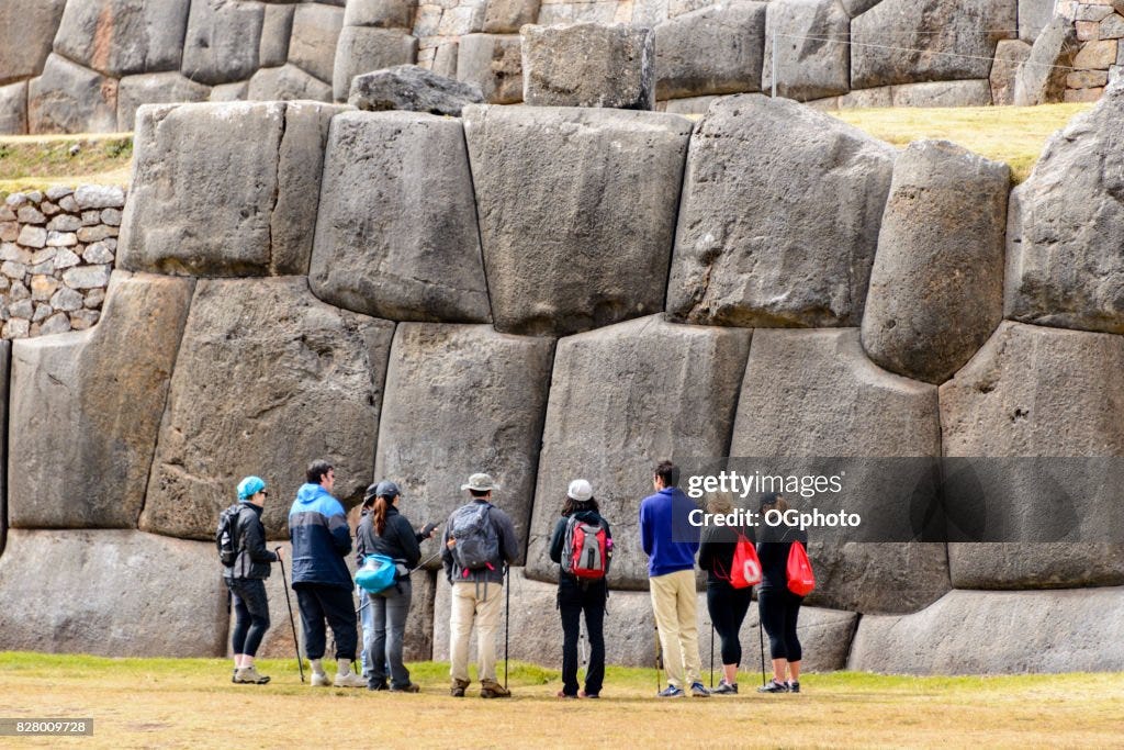 Toeristische voor enorme stenen muur op Saqsaywaman, Peru