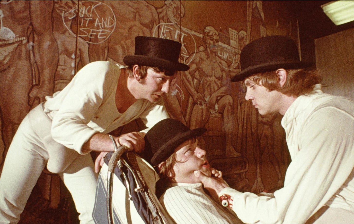 Picture of three hodlums, in their jockstraps and white pajamas and bowler hats, from the film Clockwork Orange