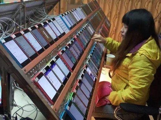 The famous image of a Chinese click farm worker with a bank of phones creating fake clicks