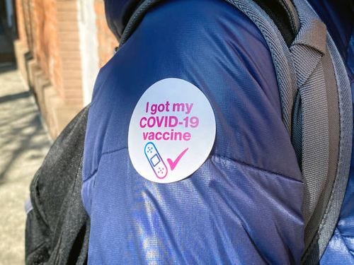 Person with "I got my COVID-19 vaccine" sticker Person with "I got my COVID-19 vaccine" sticker covid vaccine sticker stock pictures, royalty-free photos & images