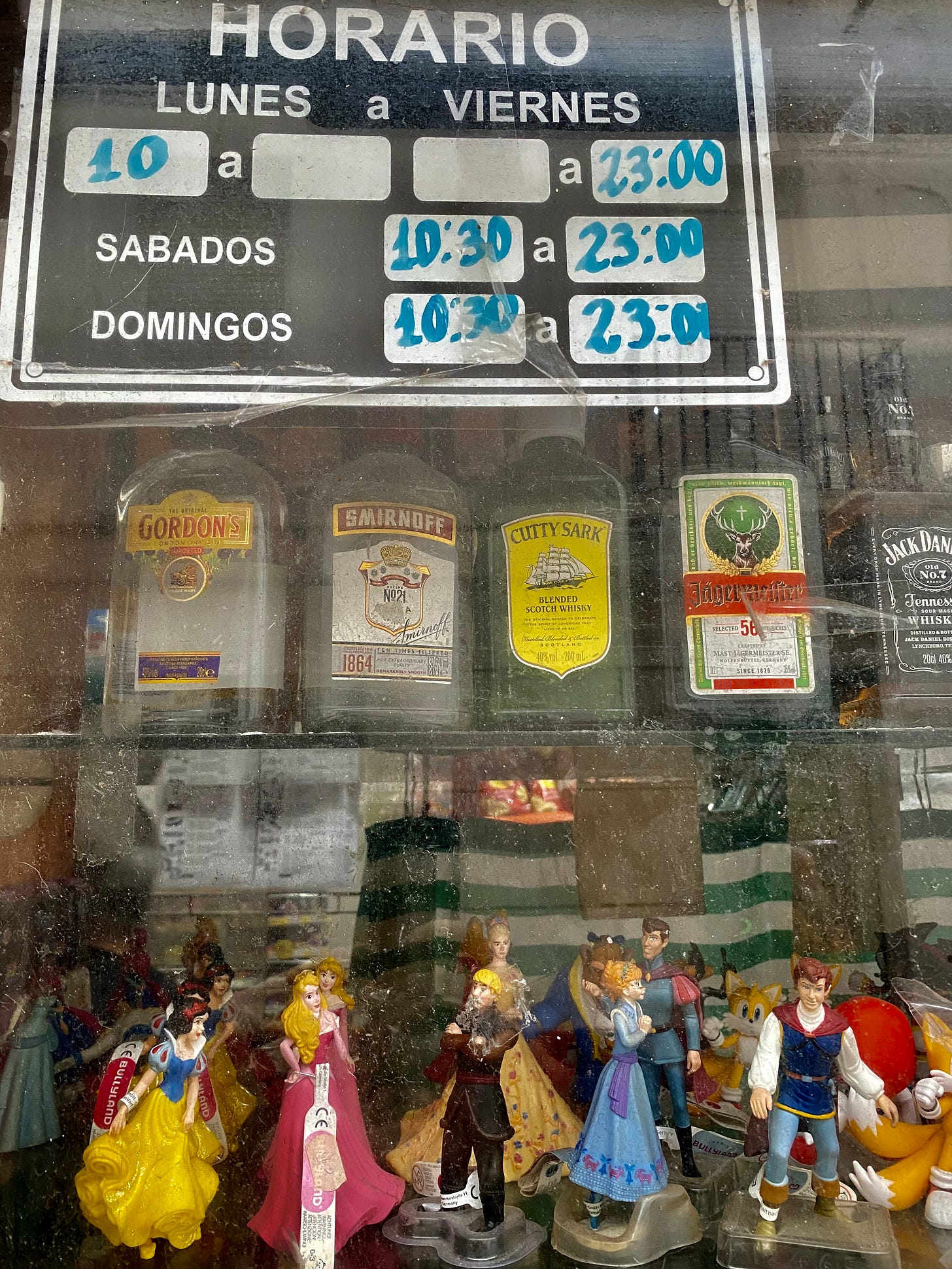 Alcohol botttle and Disney figures in a shop window