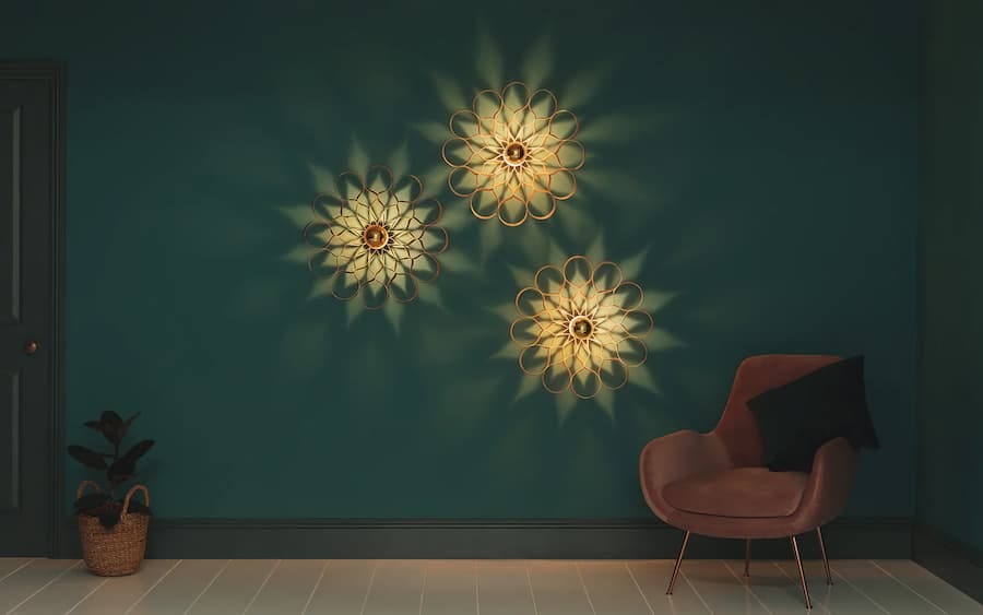 three floral inspired wall lights lit up