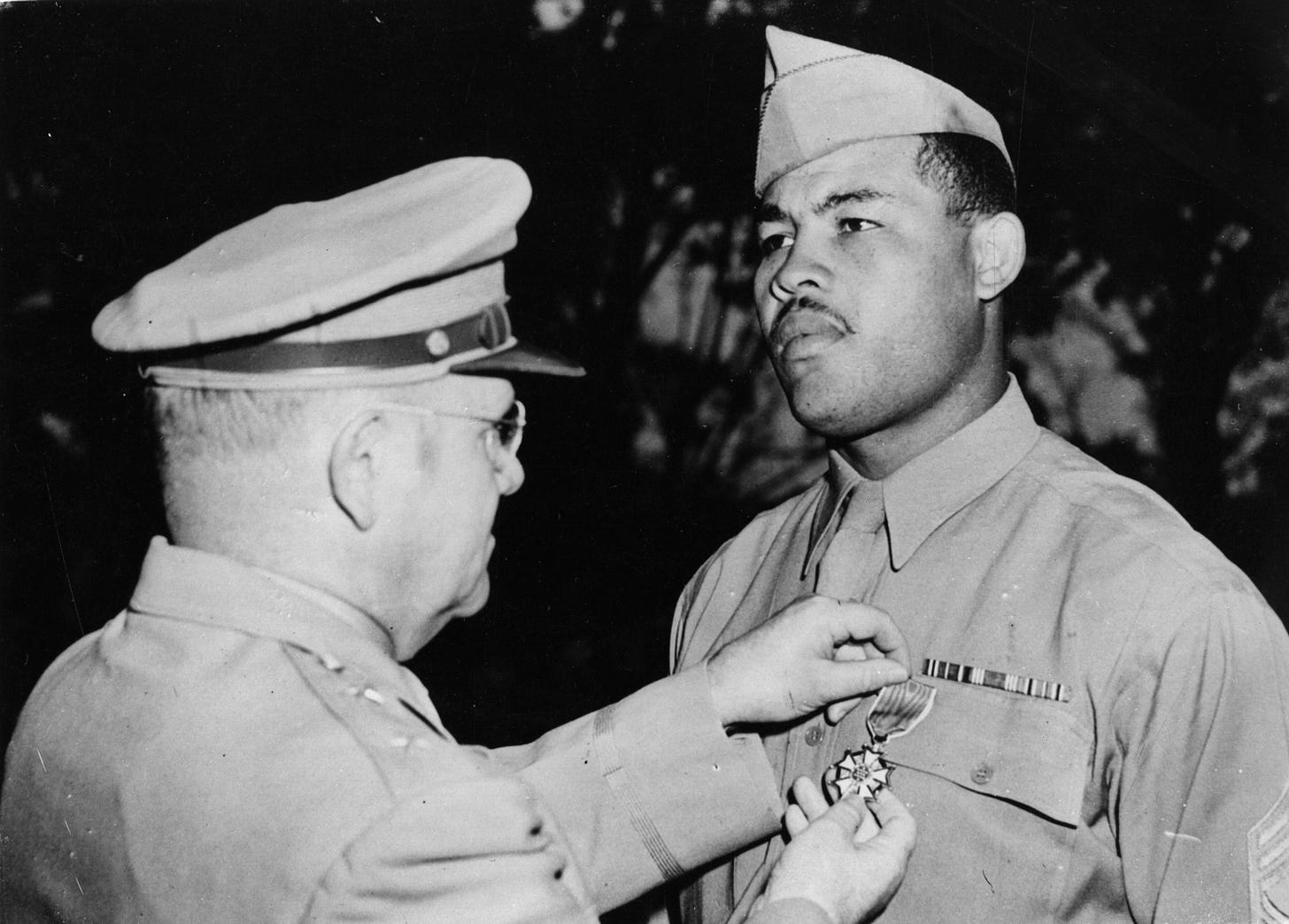 Heavyweight champion Joe Louis receiving a medal for his 'incalculable contribution to the general morale in the US army during the second world war