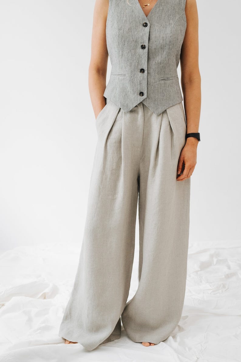 May include: A pair of wide-leg, light gray linen pants with pleats at the waist.