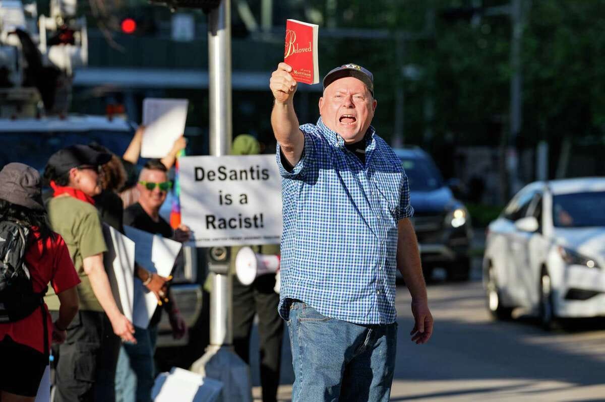 Neil Aquino, 55, holds up a book during a protest against Florida Gov. Ron DeSantis’ speech at the Harris County Republican Party’s Lincoln-Reagan Dinner at the George R. Brown Convention Center on Friday March 3, 2023, in Houston. "Banning books is undemocratic. There’s no public safety without democracy," he said.