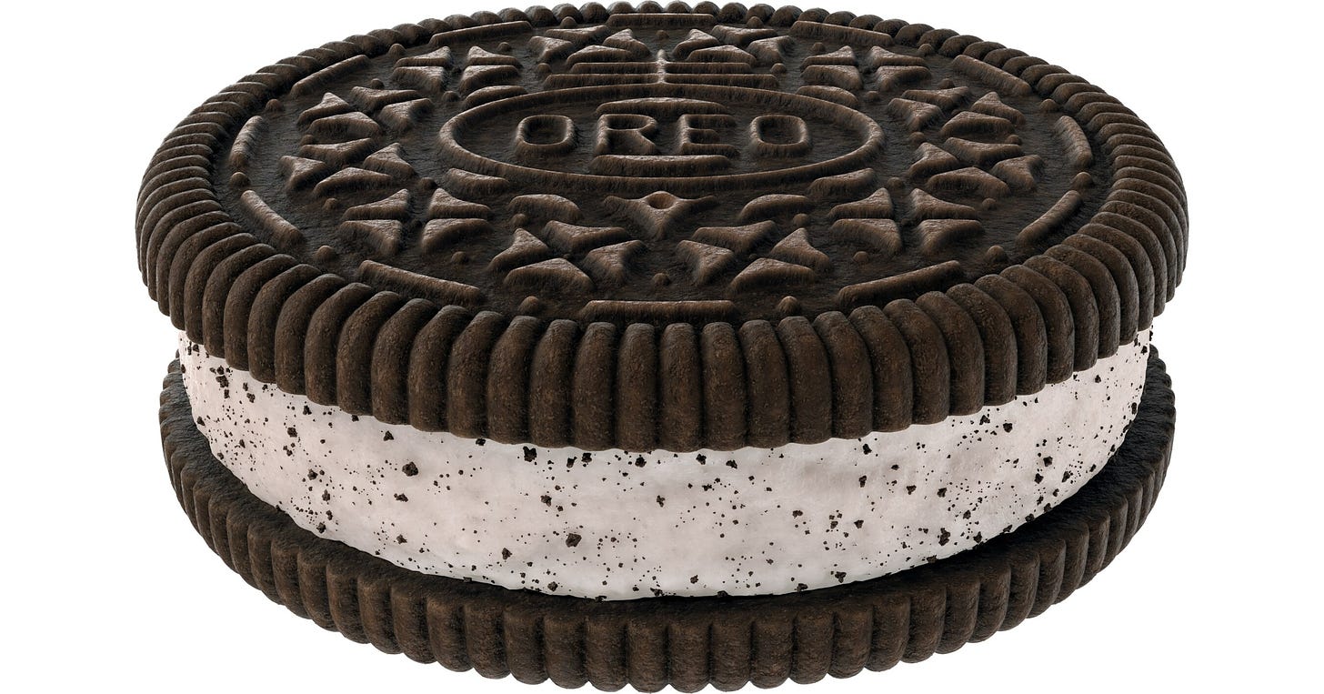 Imagem de um biscoito Oreo: chocolate por fora e chocolate branco por dentro.