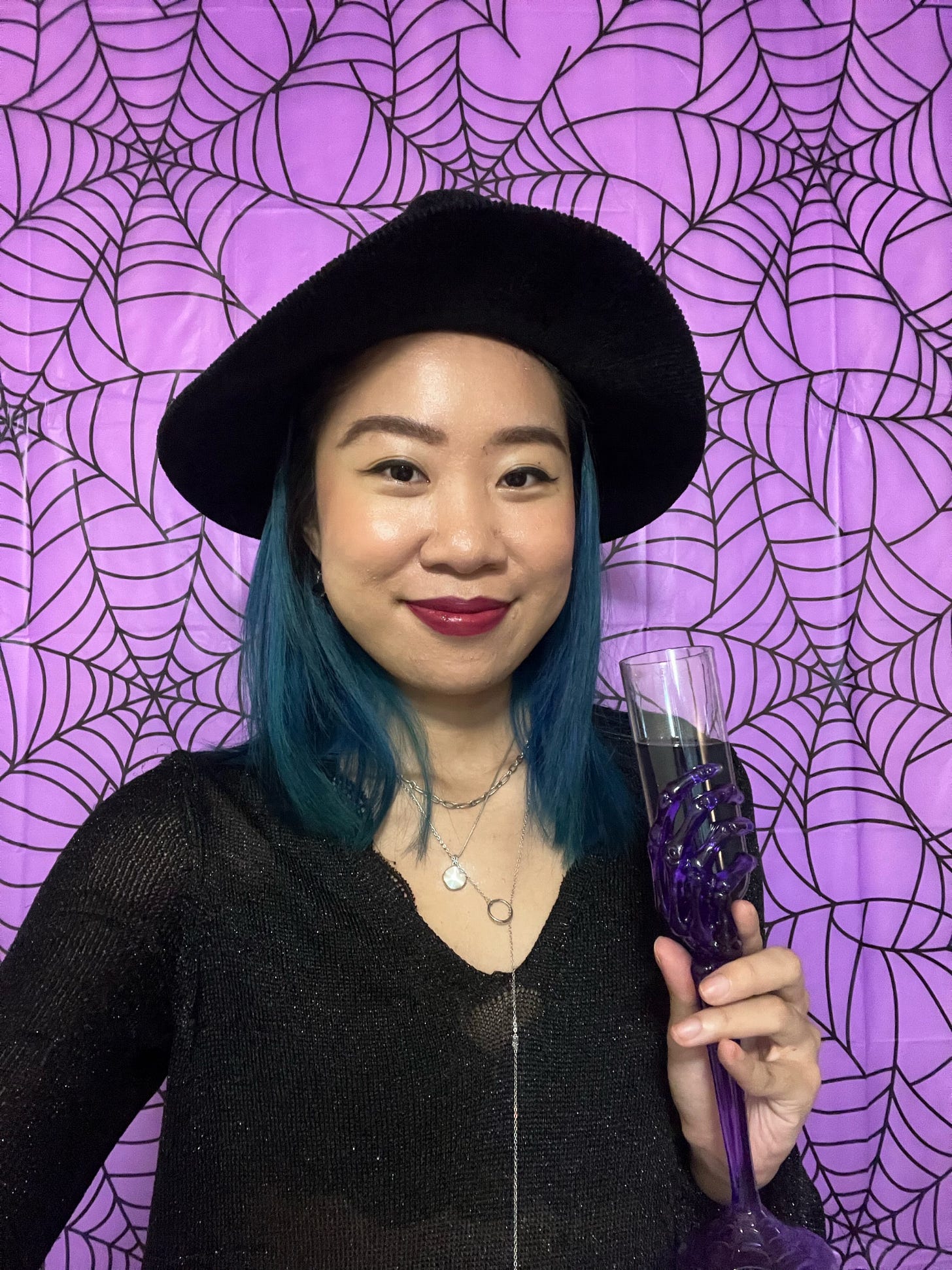 Teresa Tran halloween picture against a purple spider themed background