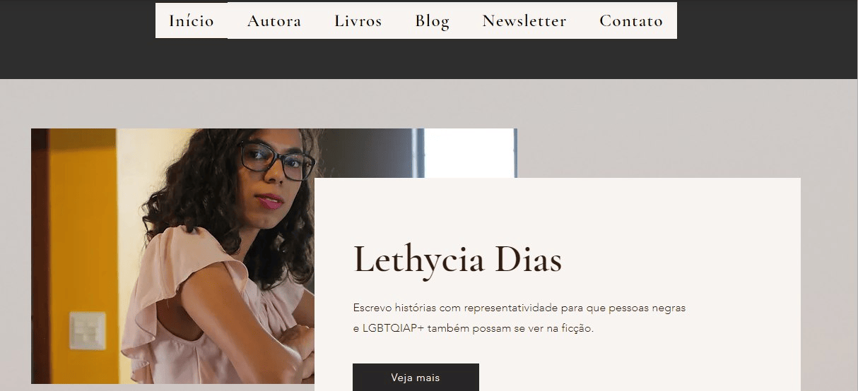 Print de tela da página inicial do meu site. No topo, há um menu branco com as opções "Início", "Autora", "Livros", "Blog", "Newsletter" e "Contato". Mais abaixo, no lado esquerdo, está uma foto minha em que estou de perfil e olho diretamente para a câmera. Ao lado, um quadro com meu nome e o texto "Escrevo histórias com representatividade para que pessoas negras e LGBTQIAP+ também possam se ver na ficção." e um botão "Veja mais"