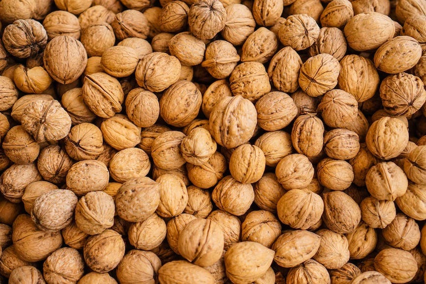 a close up image of hundreds of walnuts in their shells