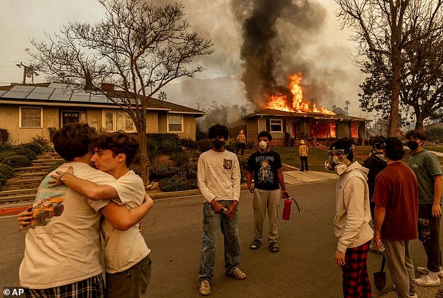 Residents embrace outside of a burning property as the Eaton Fire swept through Wednesday, Jan. 8, 2025 in Altadena, California