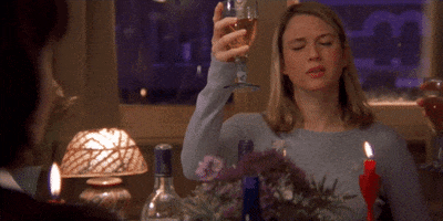 Gif of Bridget Jones and friends cheering at a table.
