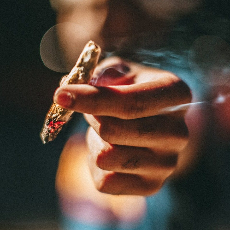 person holding lighted joint