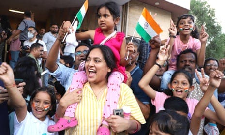 people looking happy with mouths open waving flags with arms in air